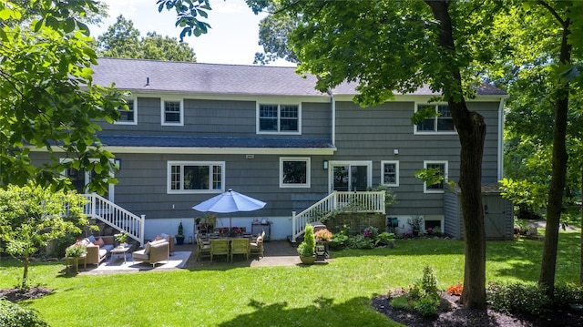 back of property with a yard, an outdoor living space, and a patio area