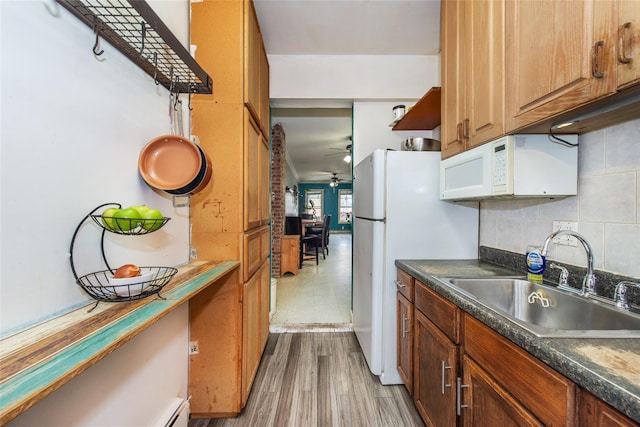 kitchen with sink, light wood-type flooring, decorative backsplash, ceiling fan, and white appliances