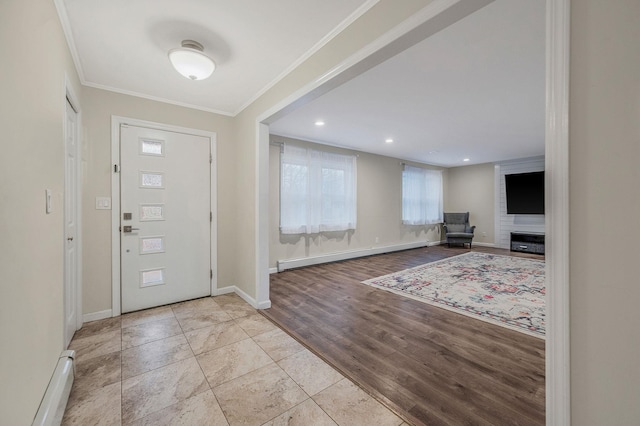 foyer with crown molding, a baseboard radiator, and light wood-type flooring