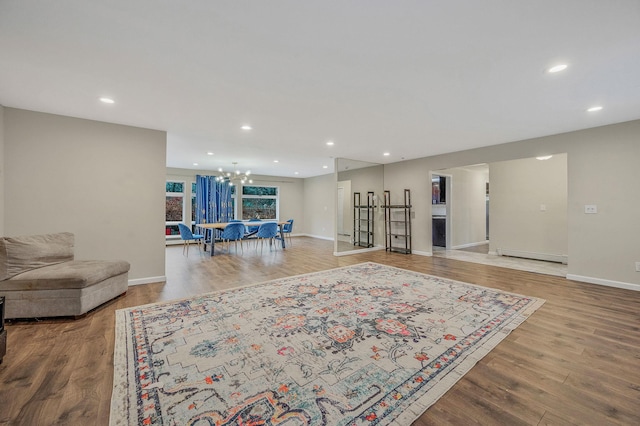 living room featuring an inviting chandelier, a baseboard radiator, and light wood-type flooring