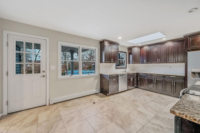 kitchen featuring a skylight, decorative backsplash, baseboard heating, stainless steel appliances, and dark brown cabinets