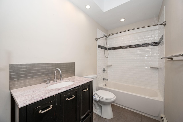 full bathroom featuring tiled shower / bath, tasteful backsplash, vanity, toilet, and tile patterned floors