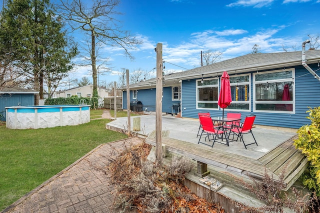 back of house featuring a swimming pool side deck and a yard