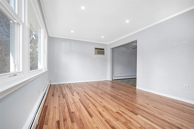 spare room featuring baseboard heating, an AC wall unit, crown molding, and light wood-type flooring