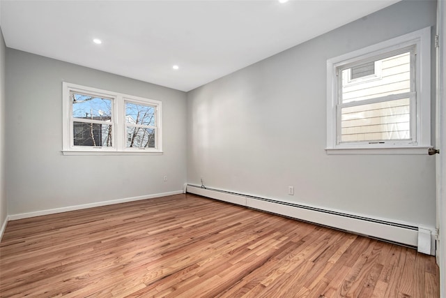 unfurnished room featuring light hardwood / wood-style floors and baseboard heating