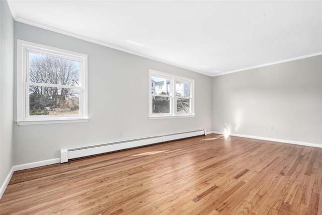 spare room featuring light wood-type flooring, crown molding, a baseboard radiator, and plenty of natural light