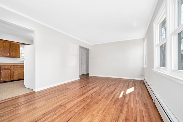 empty room featuring ornamental molding, a baseboard heating unit, and light hardwood / wood-style flooring