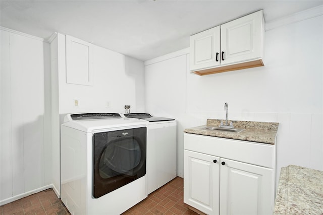 washroom with cabinets, separate washer and dryer, and sink