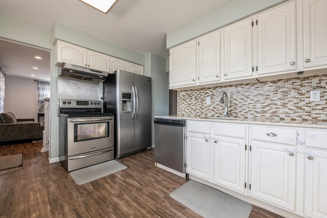 kitchen with appliances with stainless steel finishes, sink, white cabinets, dark hardwood / wood-style flooring, and decorative backsplash