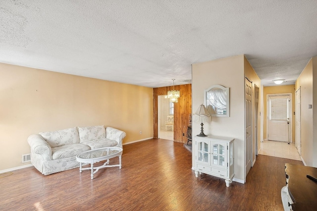 living room featuring dark hardwood / wood-style floors, a chandelier, and a textured ceiling