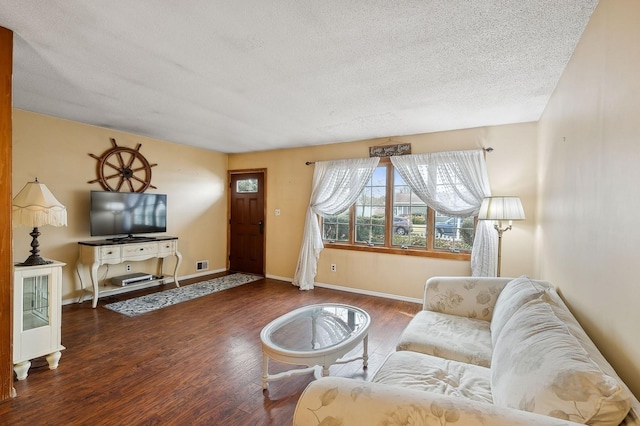 living room with dark hardwood / wood-style flooring and a textured ceiling