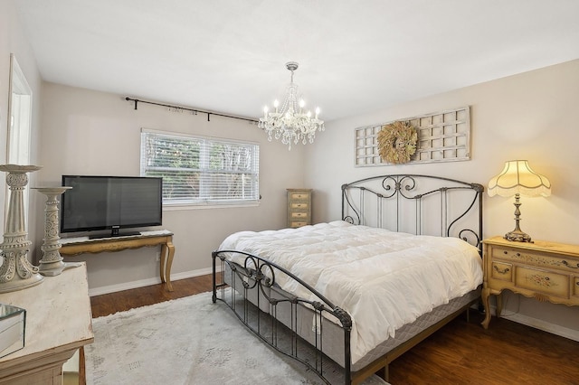 bedroom featuring a notable chandelier and hardwood / wood-style flooring