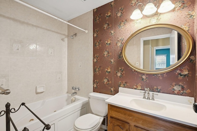 full bathroom featuring vanity, tiled shower / bath combo, and toilet