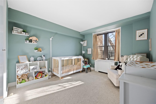 carpeted bedroom with a nursery area