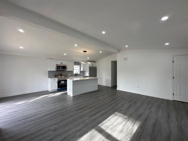 unfurnished living room featuring vaulted ceiling with beams and dark hardwood / wood-style flooring