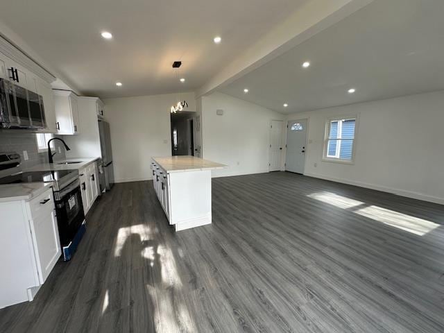 kitchen featuring white cabinetry, sink, a kitchen island, and appliances with stainless steel finishes