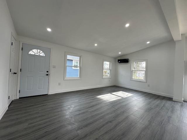 entryway with vaulted ceiling, dark hardwood / wood-style floors, and a wall mounted air conditioner