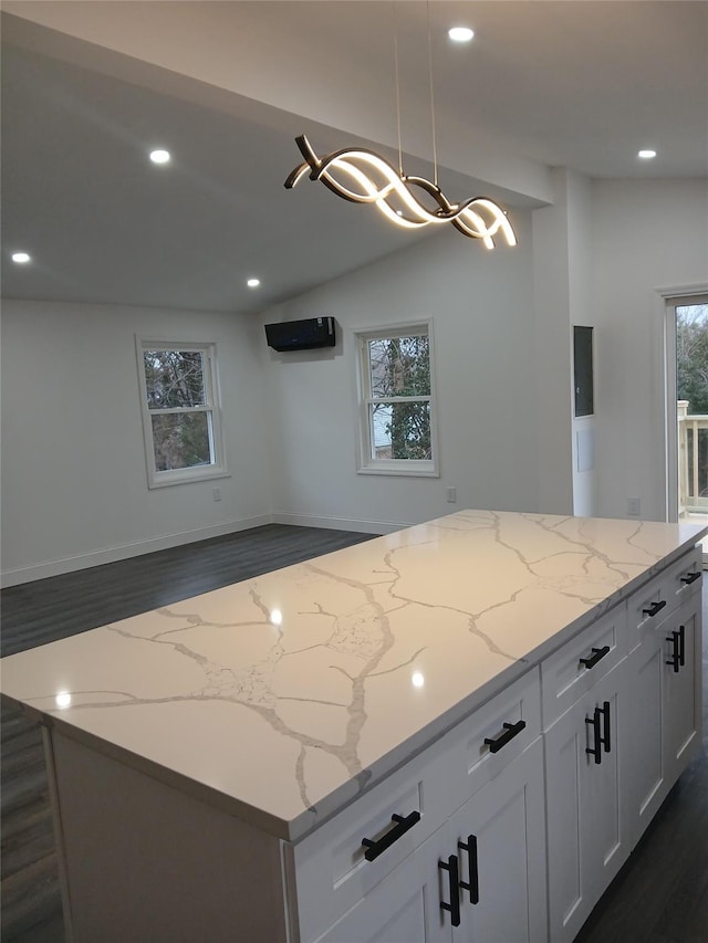 kitchen featuring white cabinetry, hanging light fixtures, light stone counters, and dark hardwood / wood-style floors