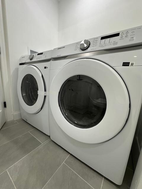 laundry area with tile patterned flooring and washing machine and dryer