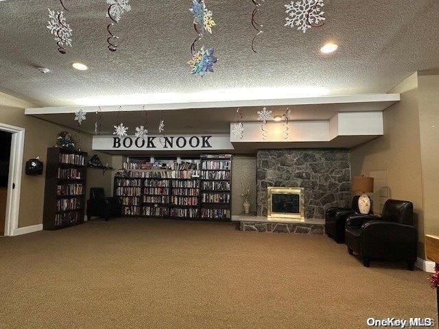 unfurnished living room featuring a fireplace, a textured ceiling, and carpet