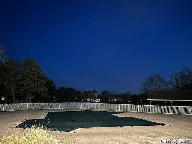 pool at twilight with a patio area