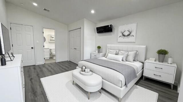 bedroom featuring lofted ceiling, connected bathroom, recessed lighting, visible vents, and dark wood finished floors