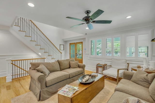 living room with crown molding, ceiling fan, and light hardwood / wood-style flooring