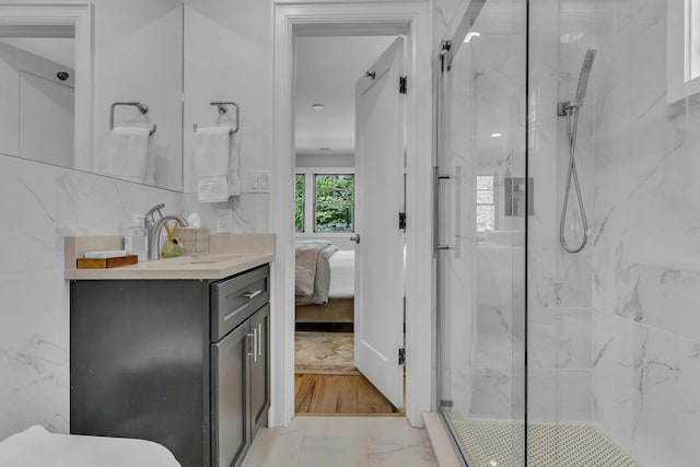 bathroom with a shower with door and vanity