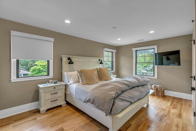 bedroom with multiple windows and light hardwood / wood-style floors