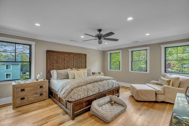 bedroom with crown molding, light hardwood / wood-style flooring, and ceiling fan