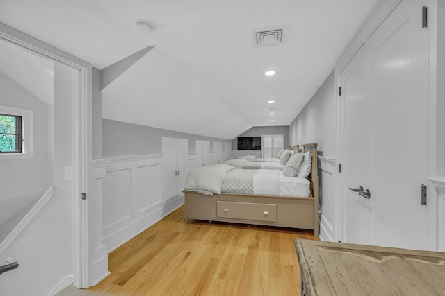 bedroom with lofted ceiling and light hardwood / wood-style flooring