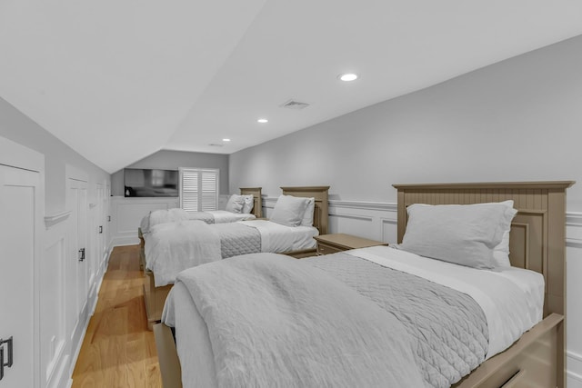 bedroom featuring lofted ceiling and light hardwood / wood-style flooring