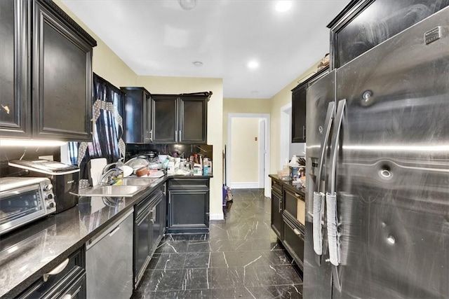 kitchen with backsplash, stainless steel appliances, sink, and dark stone counters