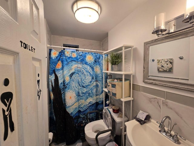 bathroom featuring a shower with shower curtain, toilet, sink, and tile walls