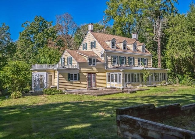 back of house featuring a yard and french doors