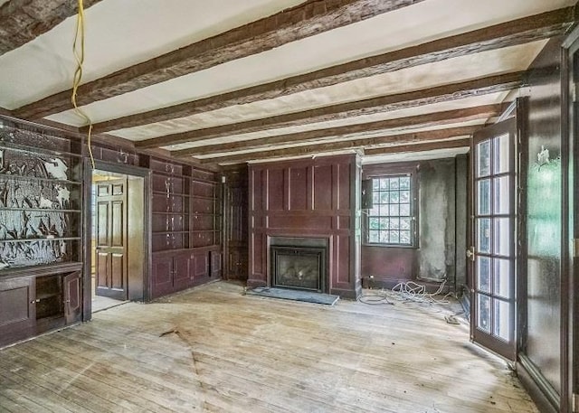 miscellaneous room with beamed ceiling and light wood-type flooring