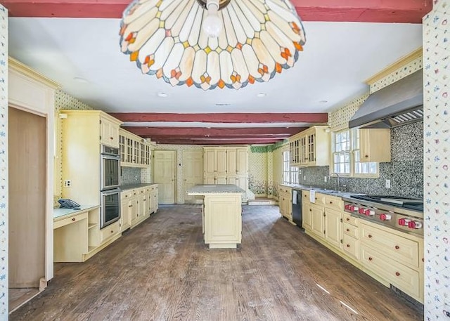 kitchen featuring dark wood-type flooring, appliances with stainless steel finishes, wall chimney exhaust hood, and a kitchen island