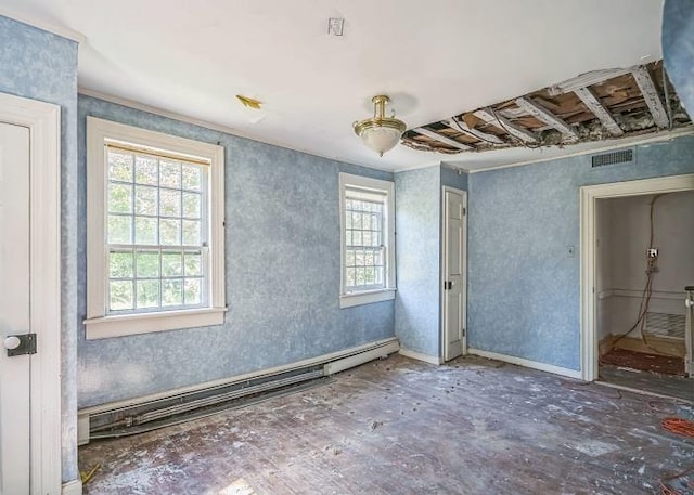 unfurnished room featuring a baseboard heating unit and a wealth of natural light