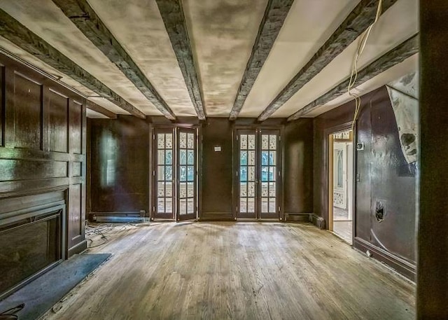 misc room with light hardwood / wood-style flooring, french doors, and beamed ceiling