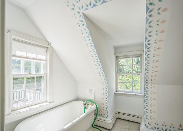 bathroom with vaulted ceiling and a tub