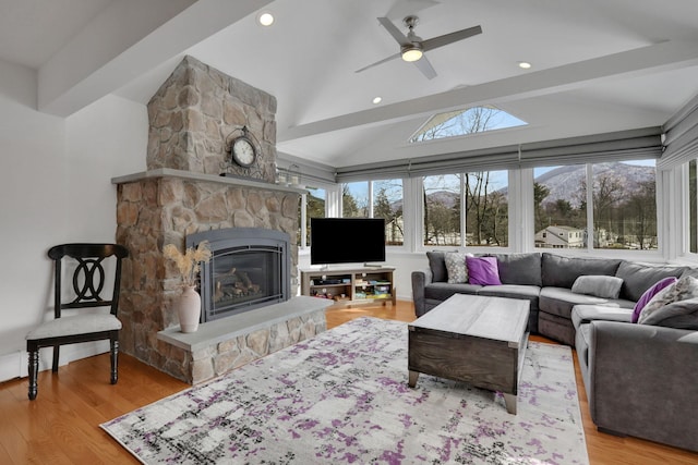 living area featuring recessed lighting, a fireplace, vaulted ceiling with beams, and wood finished floors