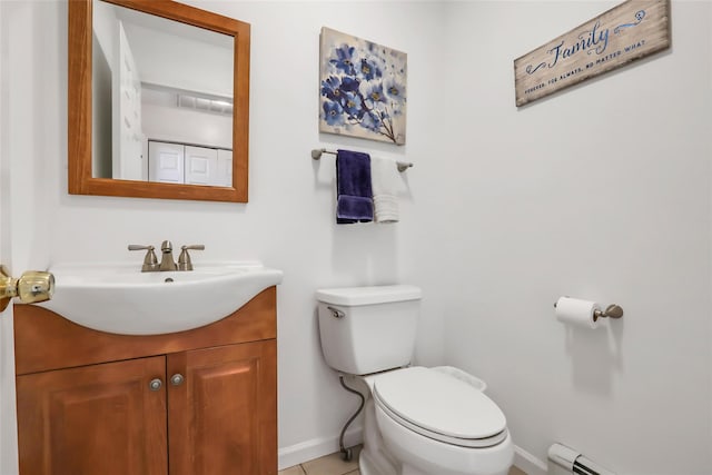 bathroom featuring a baseboard heating unit, baseboards, vanity, and toilet