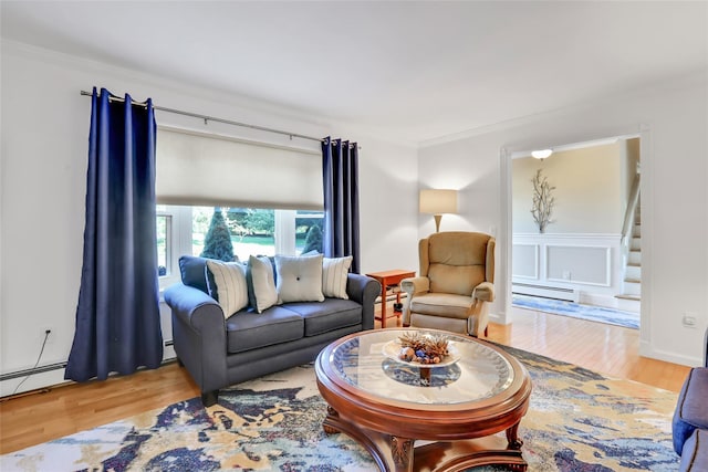 living area featuring stairway, crown molding, a baseboard heating unit, and wood finished floors