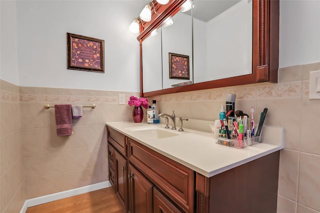 bathroom with wainscoting, tile walls, vanity, and wood finished floors