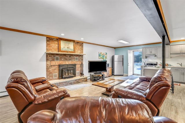 living area featuring baseboards, ornamental molding, and light wood-style floors