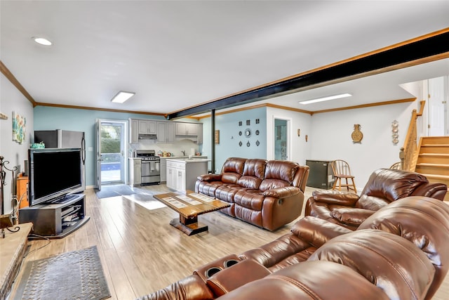 living room with stairs, light wood-type flooring, and crown molding