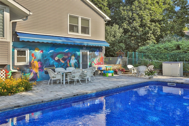 view of pool with a patio area, fence, outdoor dining area, and a fenced in pool