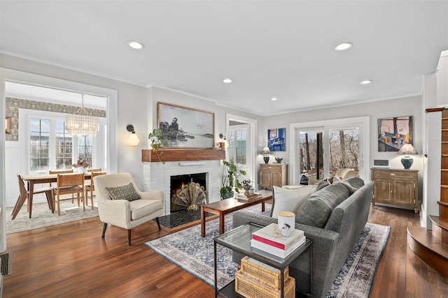 living room featuring a brick fireplace, dark wood-type flooring, and ornamental molding