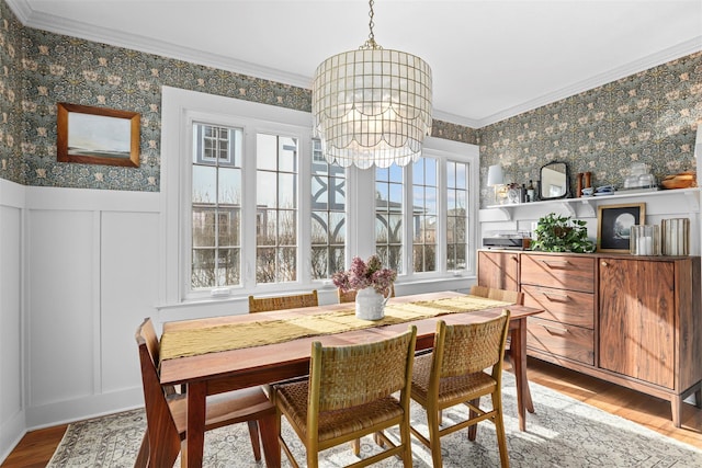 dining area featuring ornamental molding, wood-type flooring, and a notable chandelier