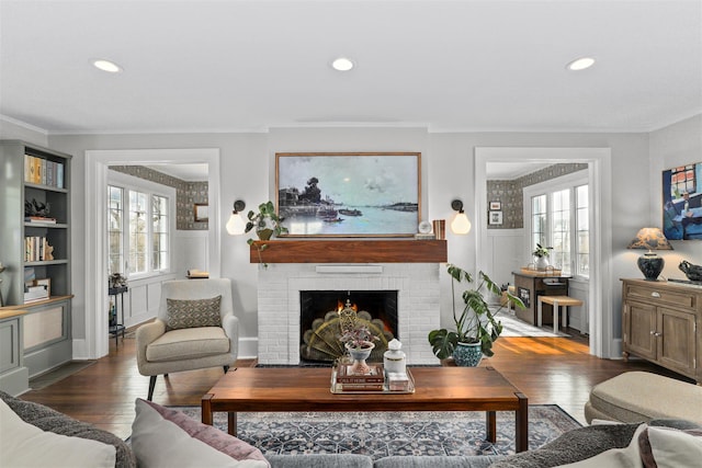 living room featuring dark hardwood / wood-style flooring, a brick fireplace, and a wealth of natural light